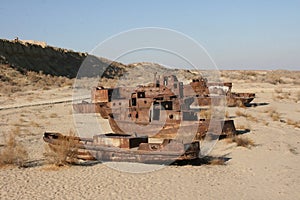 An abandoned rusty ship in the Aral sea. Ecological disaster. Dry bottom of the Aral Sea. World famous as the largest man made dis