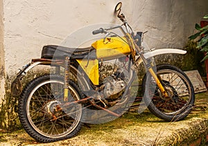 Abandoned, rusty yellow moped.