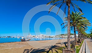 Abandoned sail boat on the beach. Mid morning sun on Ibiza waterfront. Warm sunny day along the beach in St Antoni de Portmany.