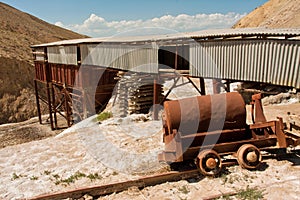 Abandoned salt mine and the rails in mountains of Central Asia under bright sun