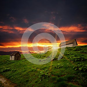 Abandoned shacks on the hill and sunset clouds