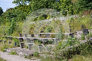 Abandoned stadium, overgrown with grass spectator stands and seats for fans, devastation and collapse