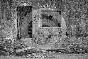 Abandoned stone building with a broken window and doorway photo