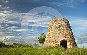 Abandoned stone windmill in sunny summer evening, Grenci, Latvia