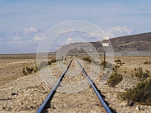 Abandoned straight railway train tracks in dry Andes Altiplano deserted landscape in Julaca Uyuni Sur Lipez Bolivia