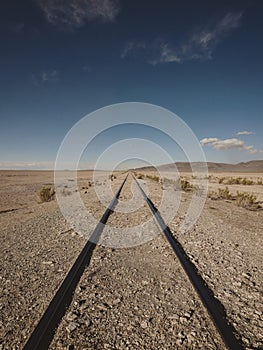 Abandoned straight railway train tracks in dry Andes Altiplano deserted landscape in Julaca Uyuni Sur Lipez Bolivia