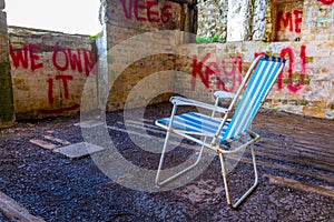 abandoned summer chair inside of an empty room decorated by various graphitti in gibraltar...IMAGE photo