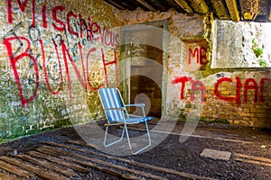 abandoned summer chair inside of an empty room decorated by various graphitti in gibraltar...IMAGE photo