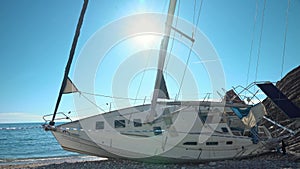 Abandoned sunken yacht washed up on seashore, fenced with tape barrier Shipwreck