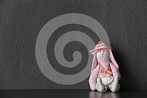 Abandoned toy bunny on table against gray background