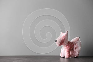 Abandoned toy dog on table against light background