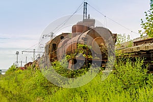 Abandoned train. Abandoned railway. Old rusty steam locomotive overgrown by plants