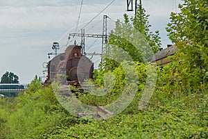 Abandoned train. Abandoned railway. Old rusty steam locomotive overgrown by plants