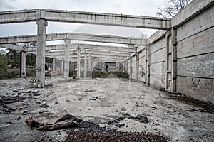 Abandoned unfinished concrete roofless hangar in cloudy day