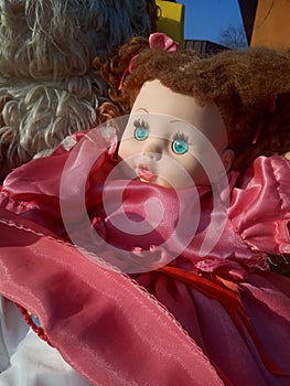 Abandoned unnecessary doll in a beautiful pink dress