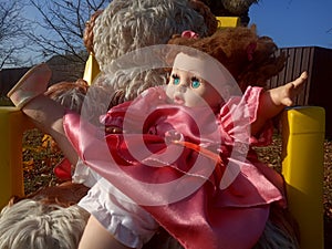 Abandoned unnecessary doll in a beautiful pink dress