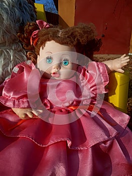 Abandoned unnecessary doll in a beautiful pink dress