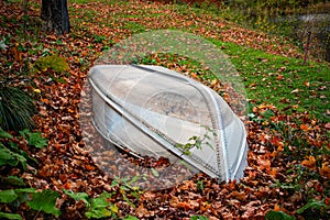 Abandoned upturned rowing boat surrounded by fall leaves, in Vermont USA