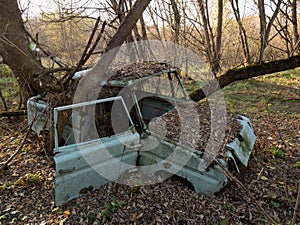 An abandoned village  and car scrap within the Chernobyl exclusion zone. Ukraine.