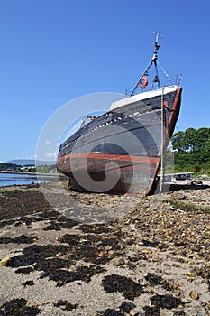 Abandoned vintage fishing boat on beach near Corpach village, Fort William, Scotland, United Kingdom