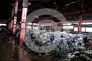 Abandoned warehouse filled with piles of clothes and discarded American flag