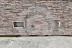 Abandoned warehouse window. Rusty grate window. Outdoor faucet water tap with white PVC pipe and reed valve on light