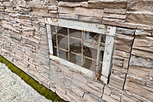 Abandoned warehouse window. Rusty grate window. Safety security protection. Light brick wall with metal grate window