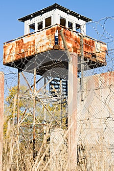 Abandoned watch-tower and prison fence wire barbs