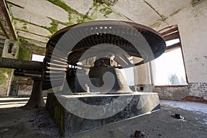 Abandoned water mill. Rusty iron wheel natural background.