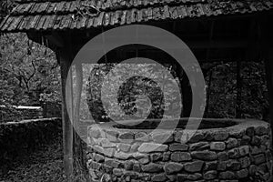 Abandoned well in the forest. Waiting for a terrible girl with a long hair. Halloween concept. Selective focus