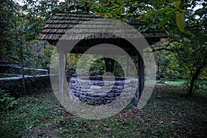 Abandoned well in the forest. Waiting for a terrible girl with a long hair. Halloween concept. Selective focus
