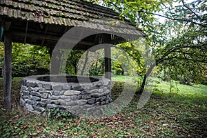 Abandoned well in the forest. Waiting for a terrible girl with a long hair. Halloween concept. Selective focus