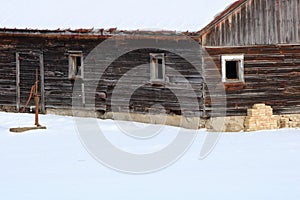 Abandoned Wood Building with Hand Water Well Pump covered with snow