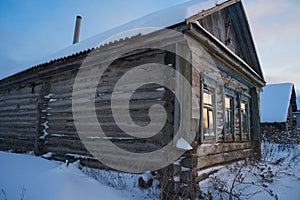 Abandoned wooden house (hut) in the Russian village in winter