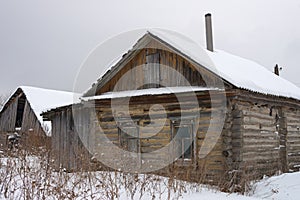 Abandoned wooden house (hut) in the Russian village in winter