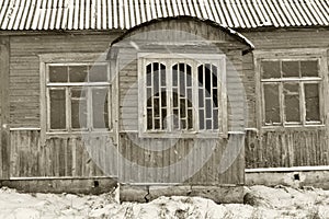 Abandoned wooden house in russian village, closeup with windows and window jamb, monochrome photo