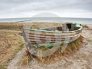 Abandoned wrecked boat stuck in sand. Old wooden boat on the sandy shore