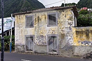 Abandoned yellow building in front of an asphalted road Seixal, madeira