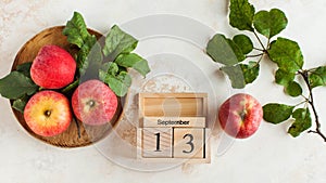 ABanner with a wooden calendar on September 13 and apples. Autumn holiday, the holiday of autumn pies and Charlotte photo
