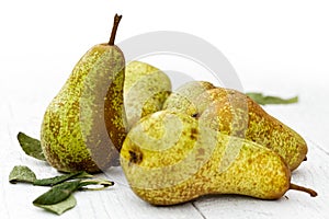 Abate fetel pears with leaves on white painted wood.