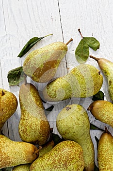 Abate fetel pears with leaves on white painted wood from above.