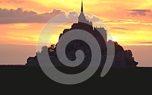 abbey of Mont Saint Michel in Normandy in France at sunset with orange sky photo