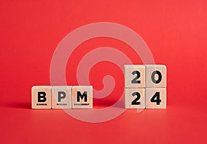 The abbreviation BPM business process management of the year 2024 on wooden cubes with red background photo