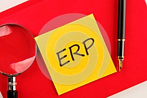 Abbreviation ERP - Enterprise Resource Planning on a yellow sticker on a red notebook