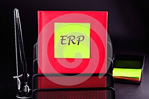 Abbreviation ERP - Enterprise Resource Planning on a yellow sticker on a red notebook. Concept photo