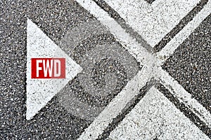 The abbreviation forward fwd written on asphalt road with direction arrows. Moving forward