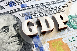 Abbreviation GDP Gross Domestic Product from wooden letters on the dollar bill photo