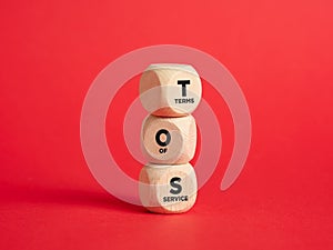 The abbreviation TOS terms of service on wooden cubes with red background photo