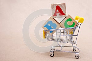 ABC blocks with English letters in a toy shopping cart. alphabet