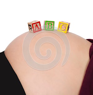 ABC blocks resting on bare pregnant belly